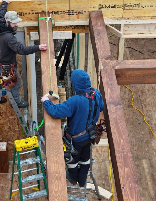 Craftsmen meticulously install custom architectural timber in Twin Cities remodeling.