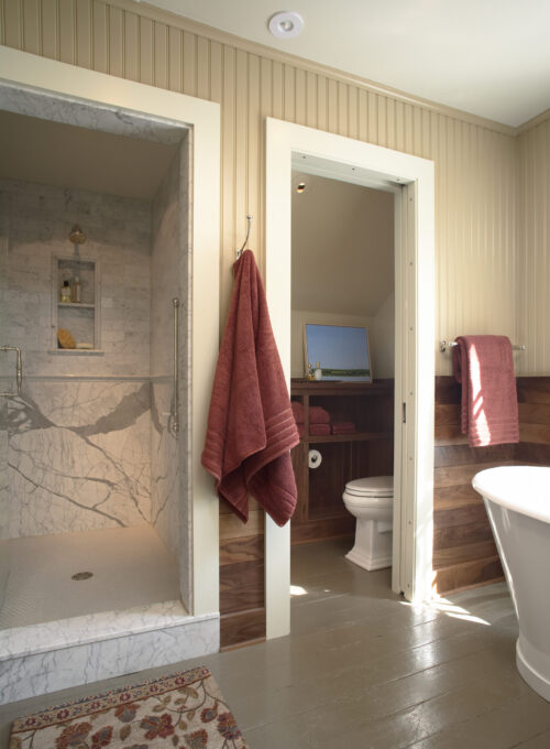 Updated Twin Cities bathroom remodel features marble shower, wood, beadboard walls.