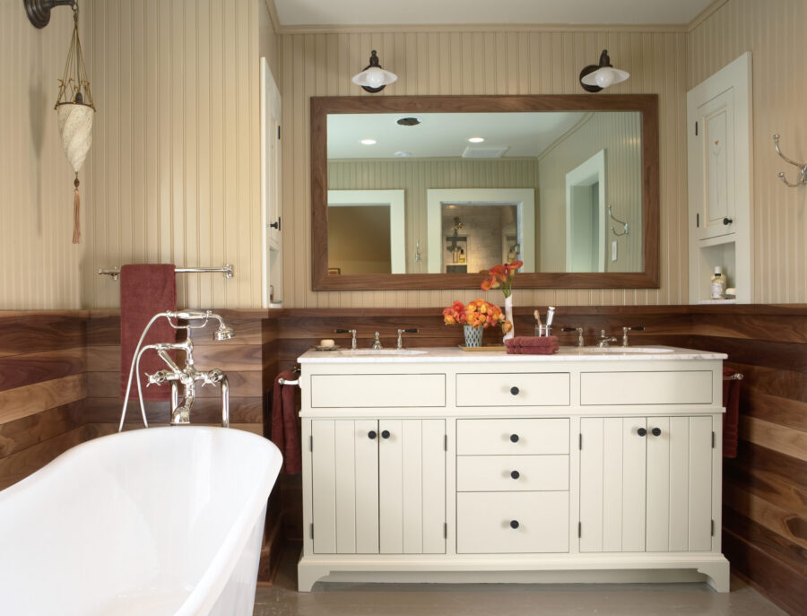 Bathroom renovation highlights rich wood, beadboard, white vanity, freestanding tub.