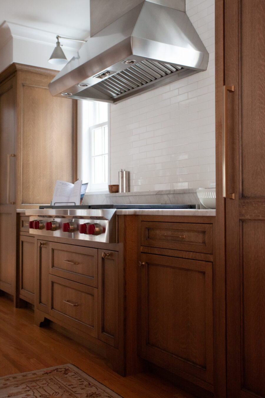 Twin Cities kitchen remodel combines dark wood cabinets, stainless range, white subway tile, and marble counters.