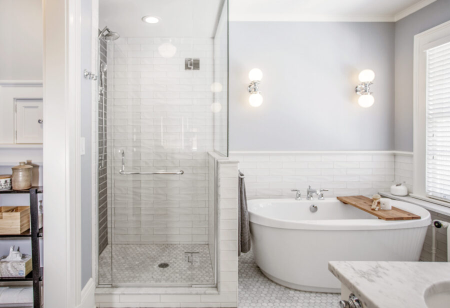 Contemporary Twin Cities bathroom remodel features a glass shower, white subway tile, and a freestanding tub.