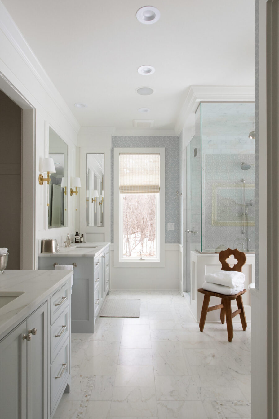 Twin Cities bathroom renovation. Marble floor, gray double-vanity, glass shower.