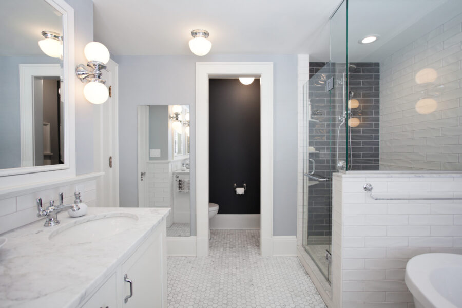 This Twin Cities bathroom remodel features a white marble vanity, hexagonal floor, and gray subway tiled shower.