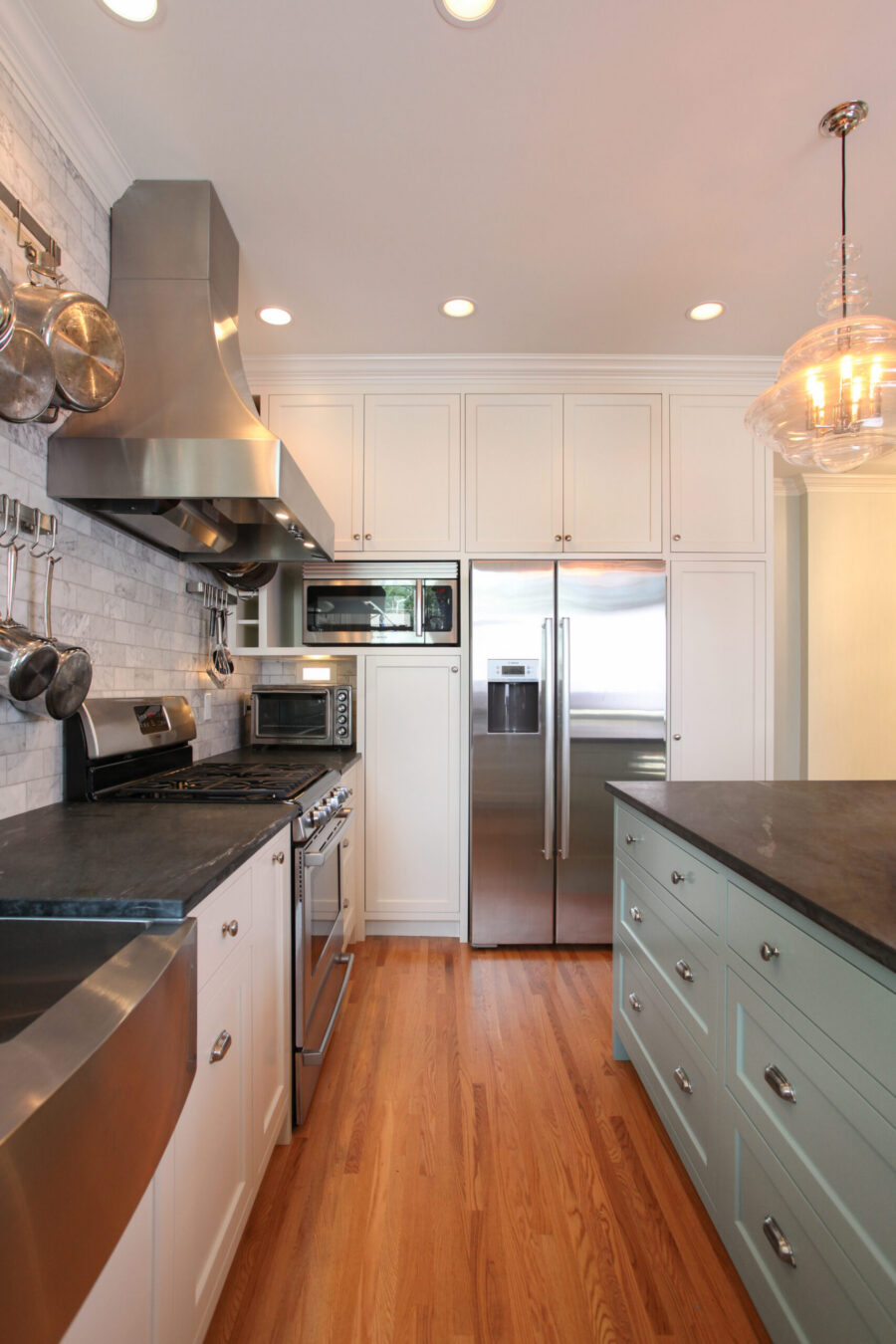 Renovated kitchen displays white cabinetry, dark countertops, stainless appliances, wood floors.