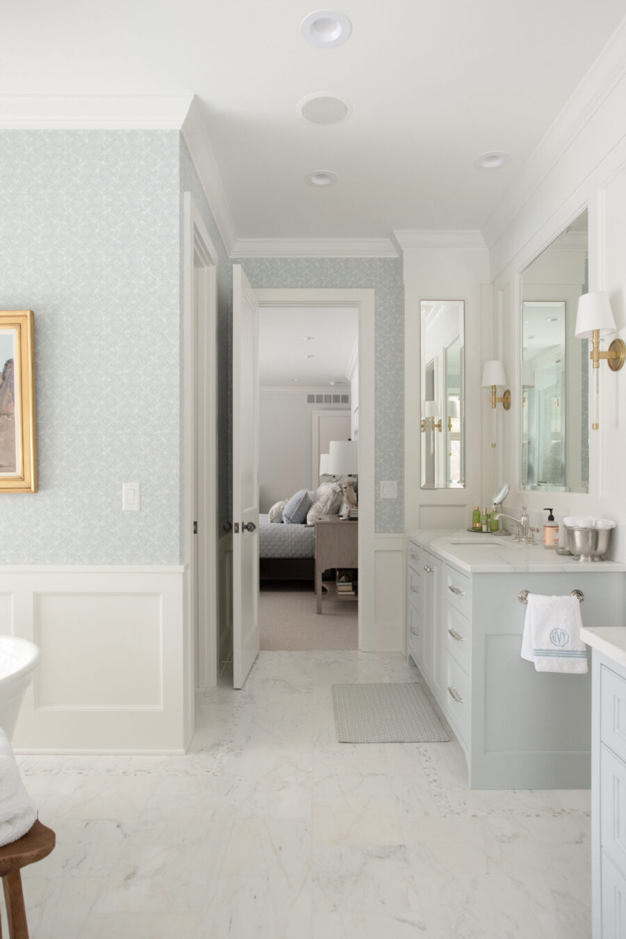 Elegant Twin Cities bathroom remodel displays blue wallpaper, wainscoting, marble floor.