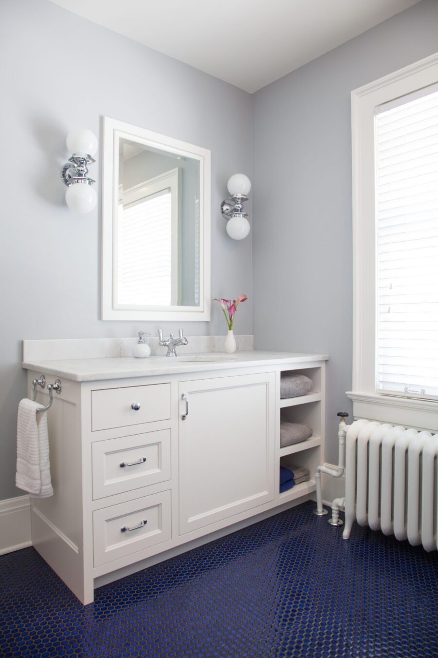 Twin Cities bathroom renovation features white custom-vanity, blue penny-tile.