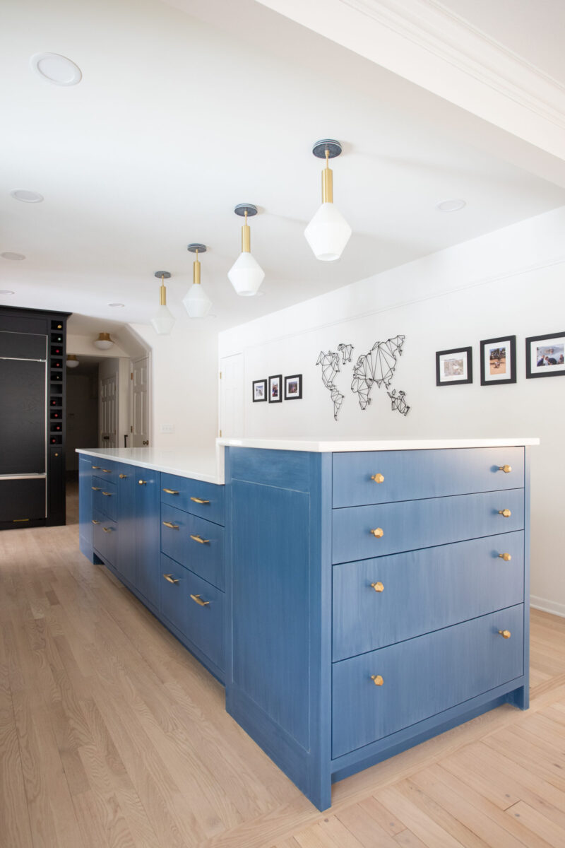 Twin Cities kitchen remodel features blue island, white counters, sleek pendant lights.