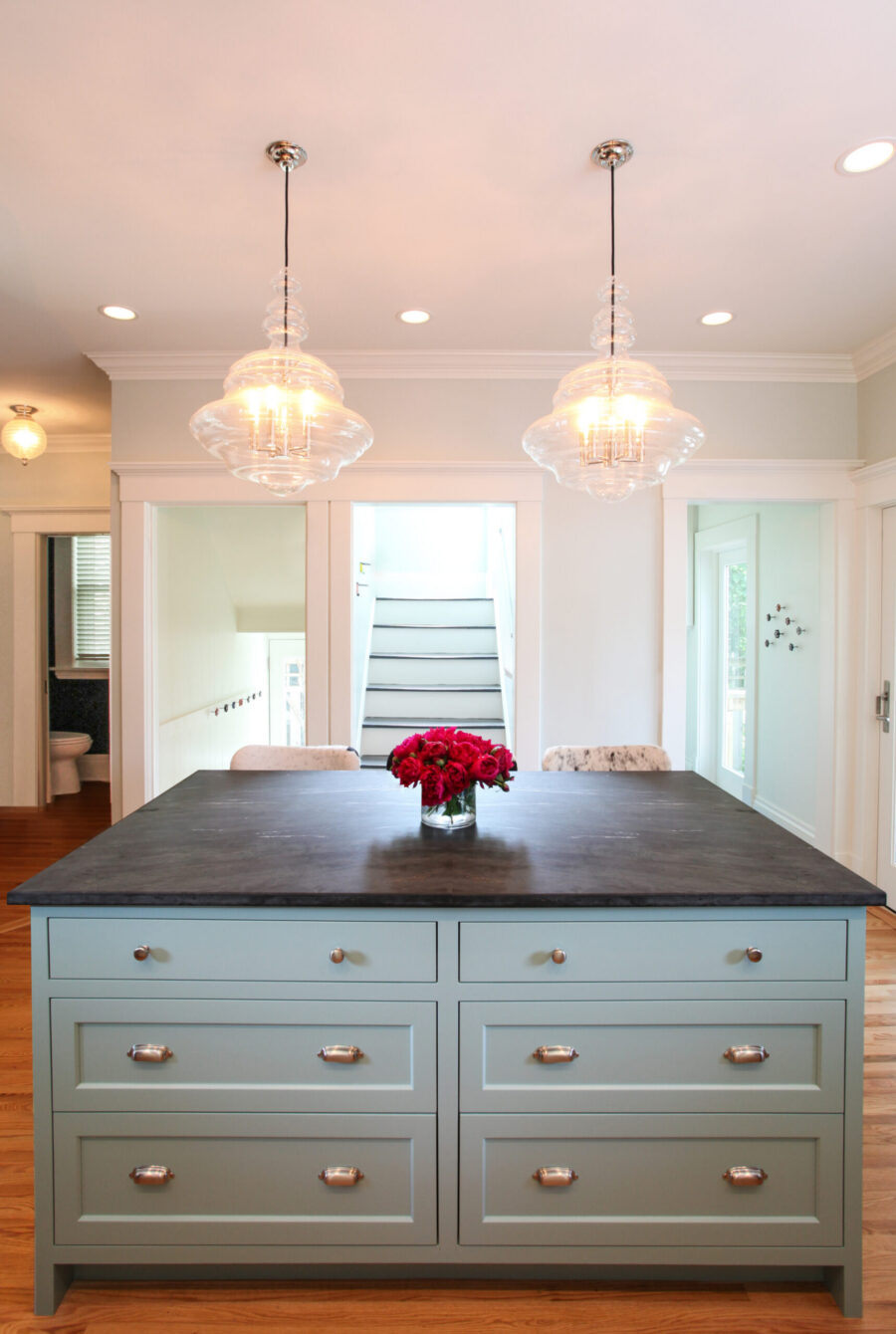 Twin Cities kitchen remodel: light-blue island, dark-stone counter, glass pendants.