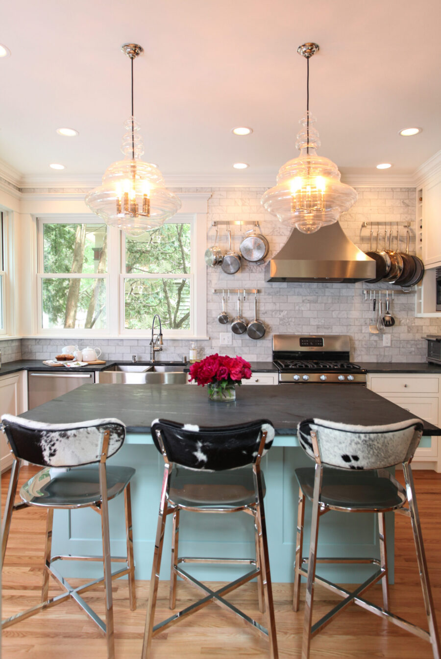 Twin Cities kitchen renovation features blue island, dark countertops, glass lighting.