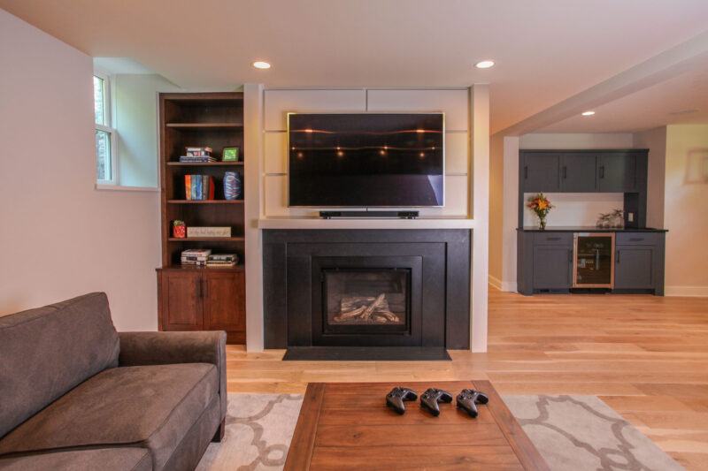 Twin Cities basement renovation: fireplace, television, wet bar, light wood floors, custom built-ins.