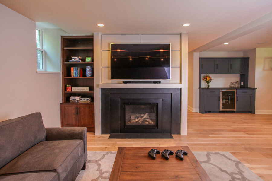Twin Cities basement renovation: fireplace, television, wet bar, light wood floors, custom built-ins.