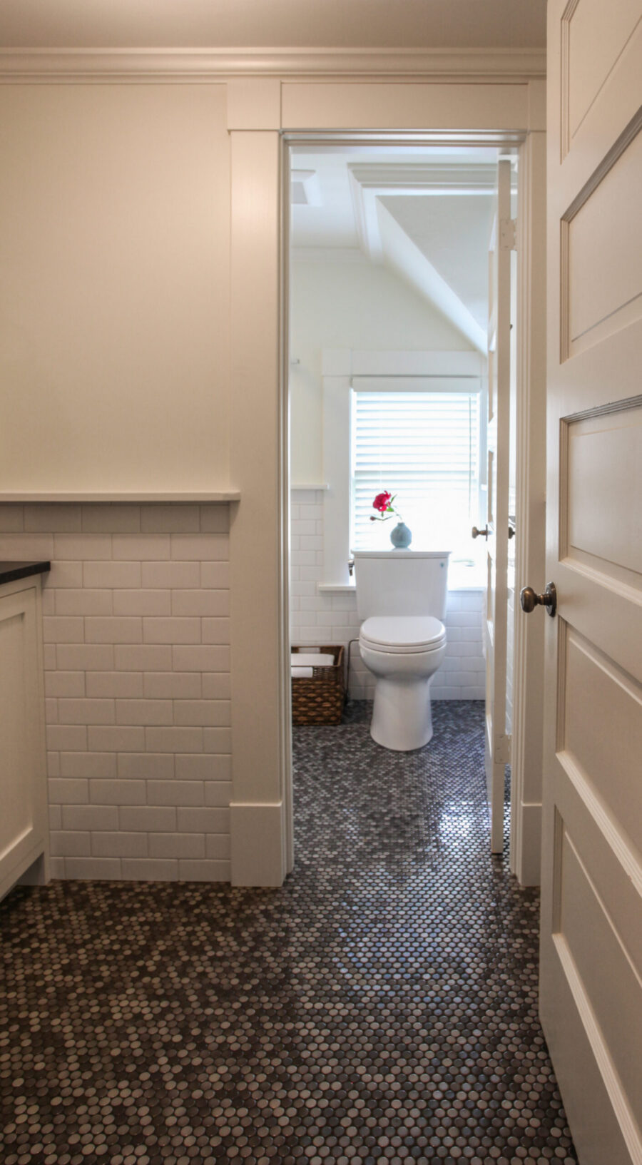 White subway tile walls and dark penny floor tile define this bright Twin Cities bathroom remodel.