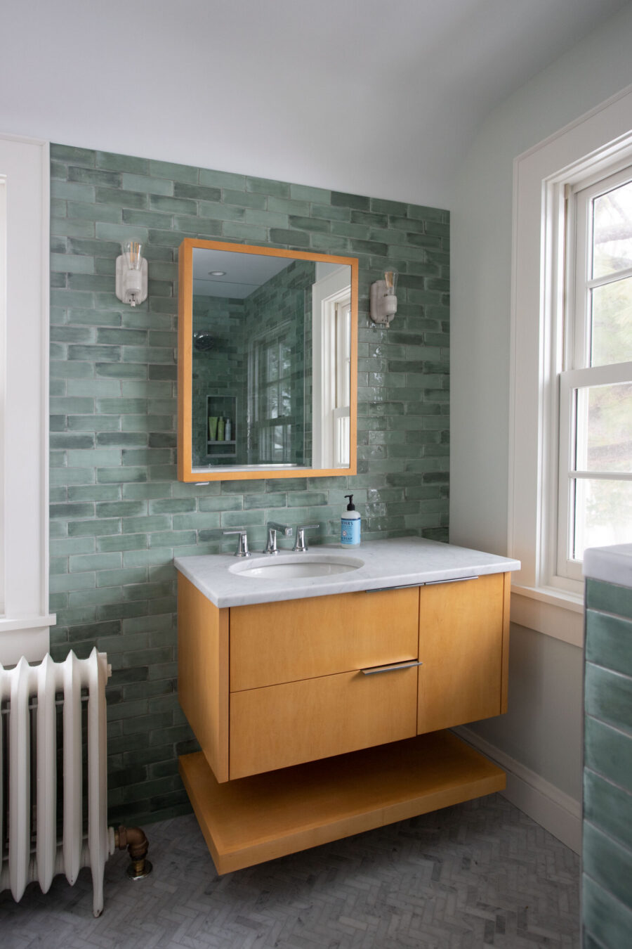 Stylish Twin Cities bathroom remodel features green rectangular tiles, floating wood vanity.