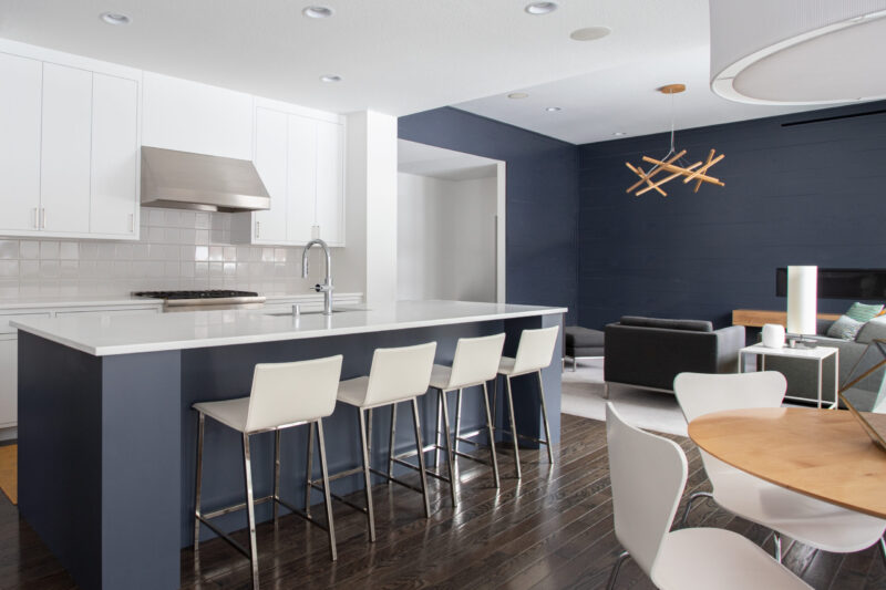 Twin Cities kitchen remodel: white cabinets, blue island, quartz countertops, dark wood flooring, open living.