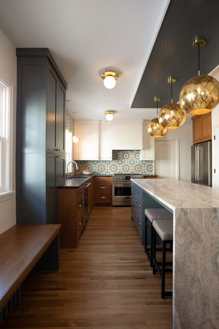 Stylish kitchen remodel, Twin Cities. Varied cabinets, colorful backsplash, large island.
