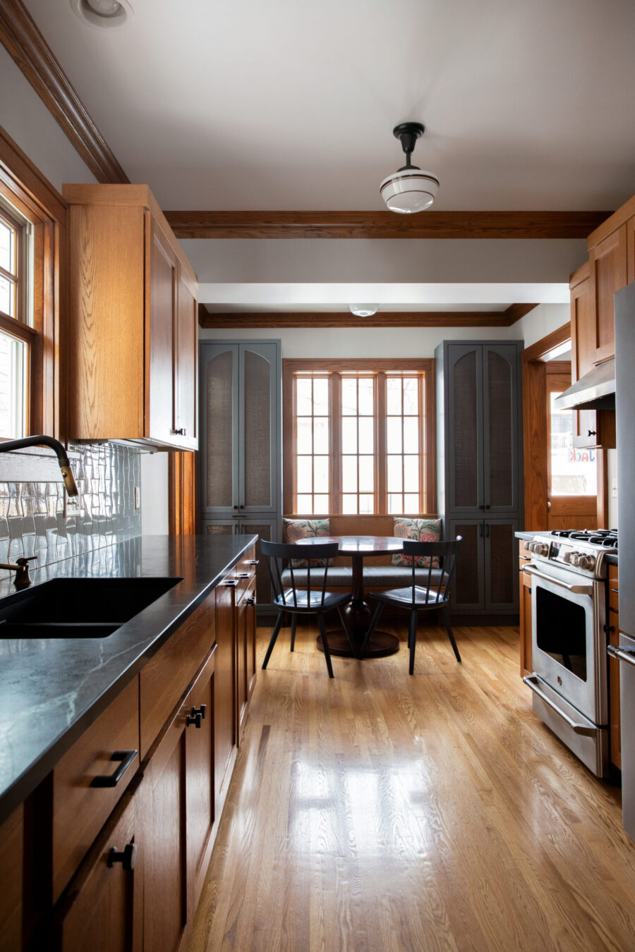 Twin Cities kitchen renovation offers wood, gray cabinets, dark counters, breakfast nook.