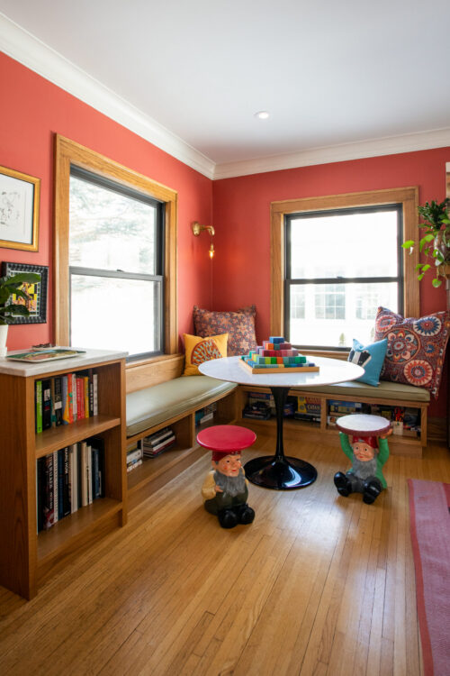 built in shelving anchors colorful interior remodel with warm wood trim and bright coral walls