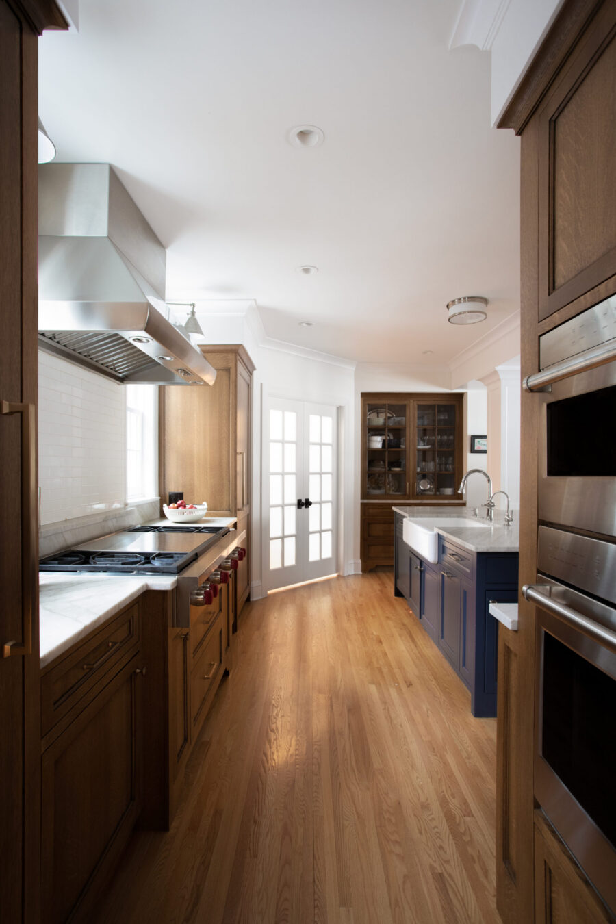 Twin Cities kitchen remodel features wood cabinetry, blue island, marble, and stainless steel appliances.