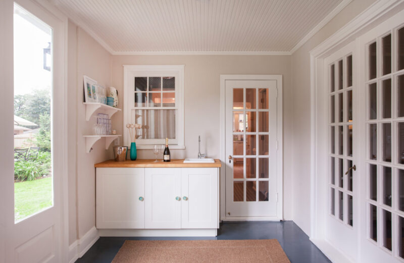 Renovated mudroom, white cabinets, light wood wet bar, French doors. Twin Cities.