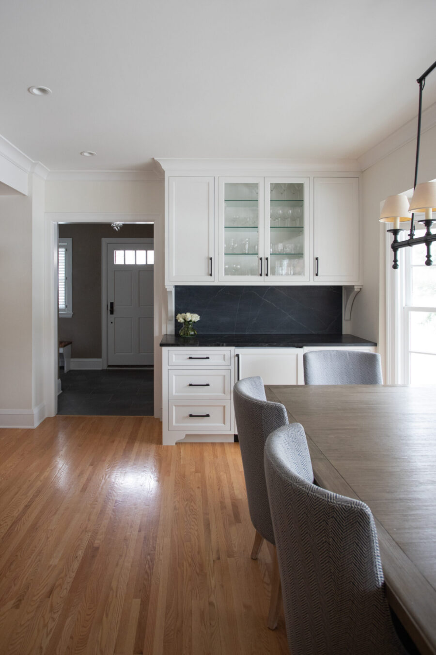 Twin Cities home renovation updates custom white cabinetry, dark stone.