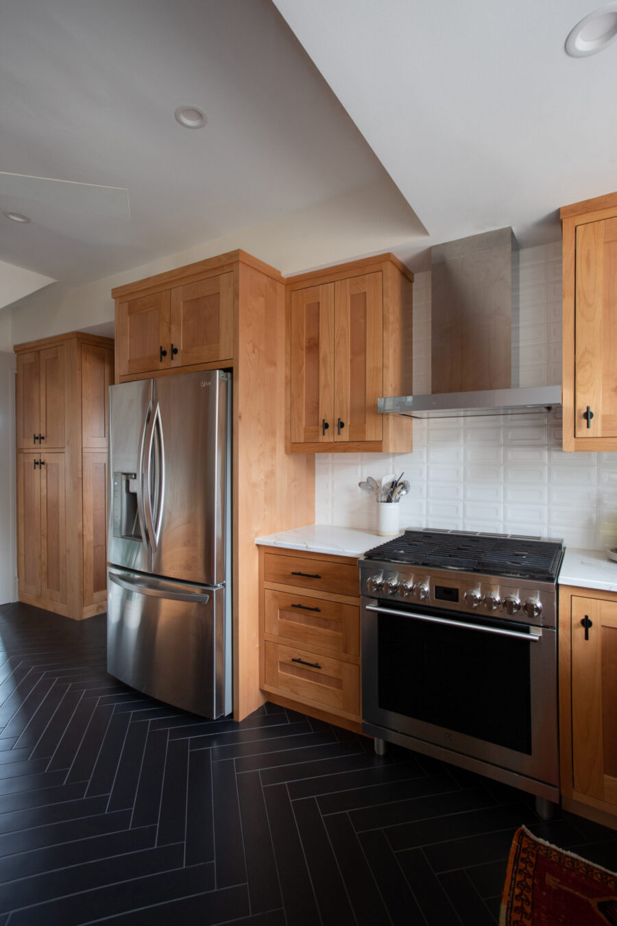 Twin Cities kitchen renovation features wood cabinets, stainless appliances, and dark tile floors.
