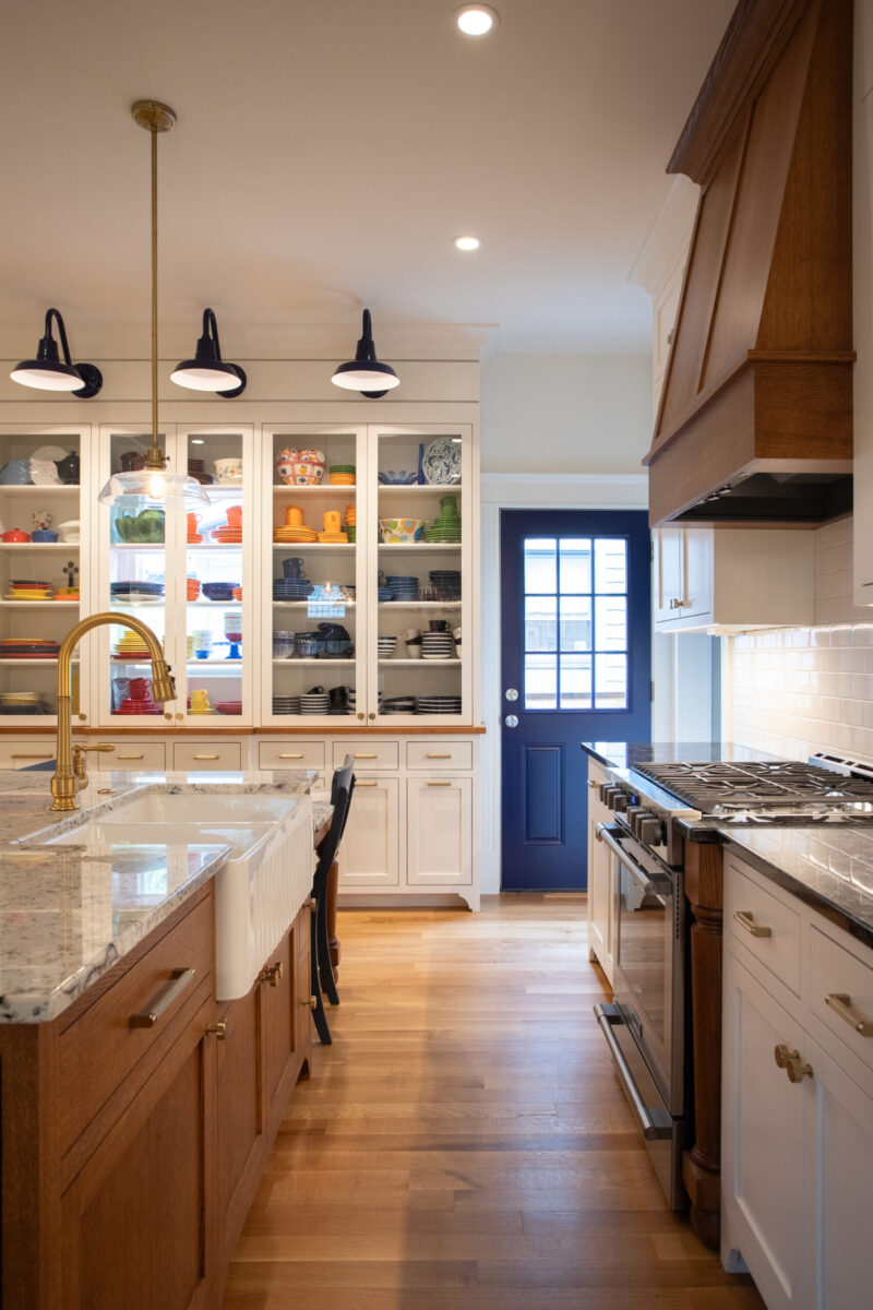 Twin Cities remodel features white cabinets, wood island, blue door, and bright modern lighting.