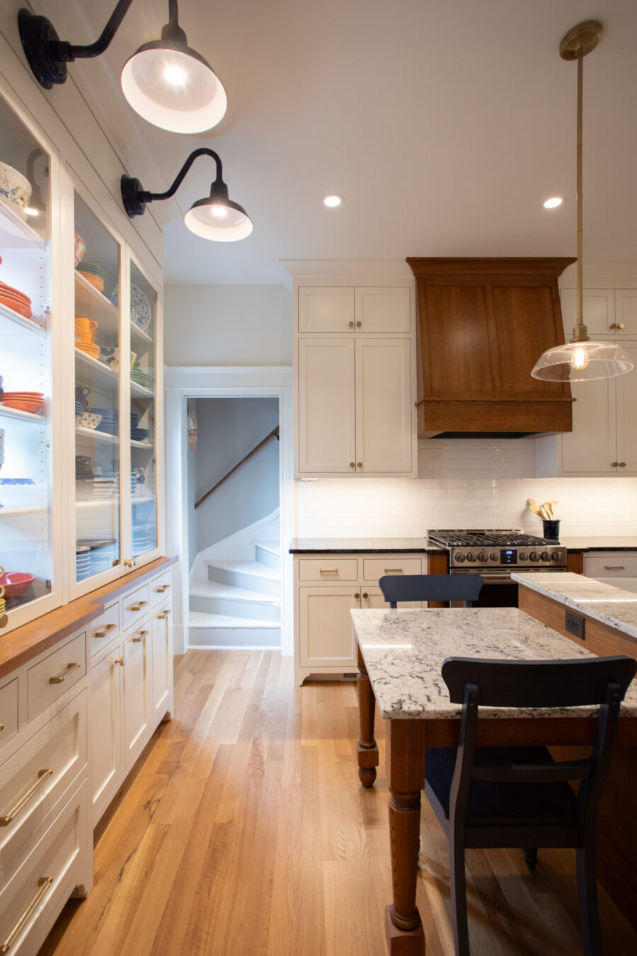 This Twin Cities kitchen remodel boasts white cabinets, wood flooring, and bright lighting.