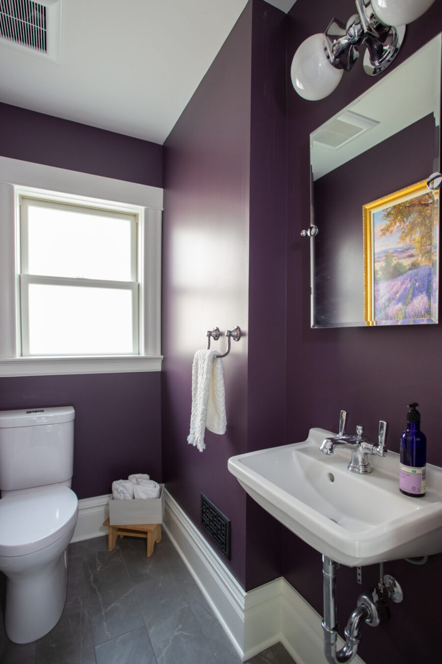 Twin Cities bathroom remodel boasts purple walls, white fixtures, and grey tile.