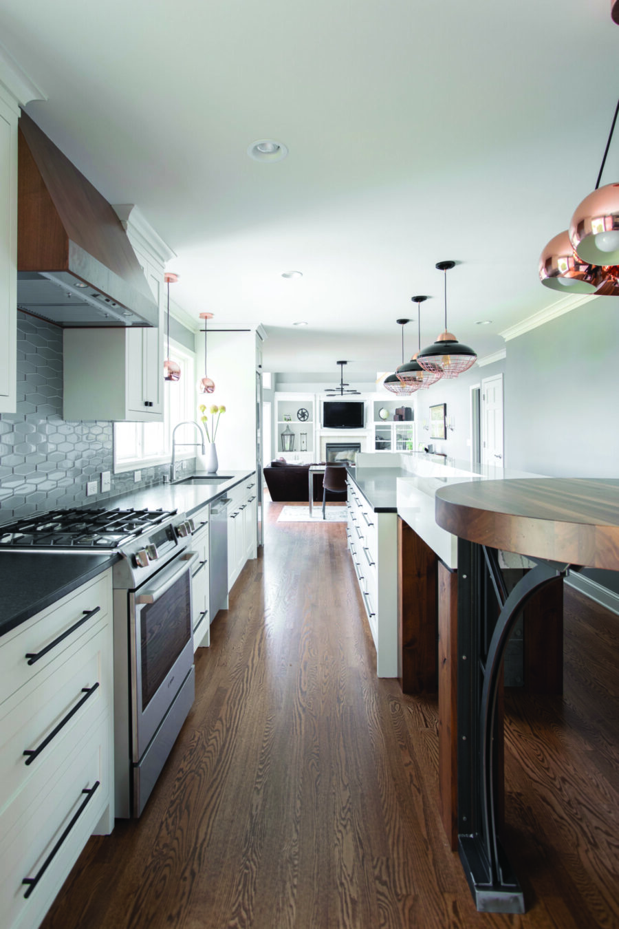 Renovated open-plan kitchen: white cabinets, dark counters, wood floors, Twin Cities design.