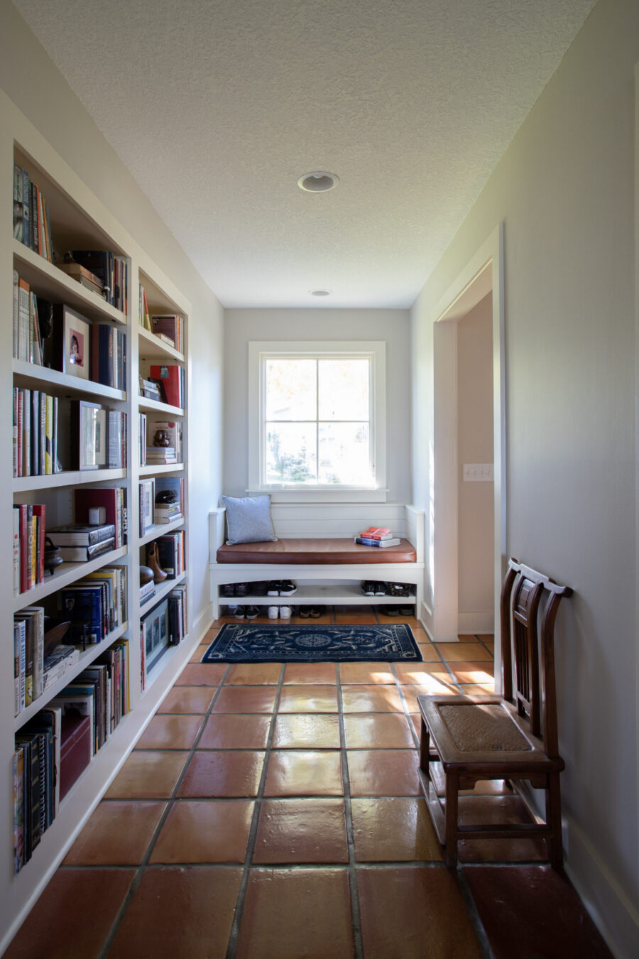 Entryway features built-in-bookshelves, window-bench, terracotta-tiles; natural-light; home-remodel, Twin-Cities.