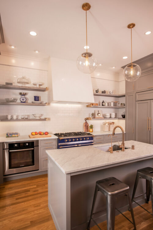 Grey-cabinetry, marble-countertops, and blue-range highlight a modern kitchen remodel.