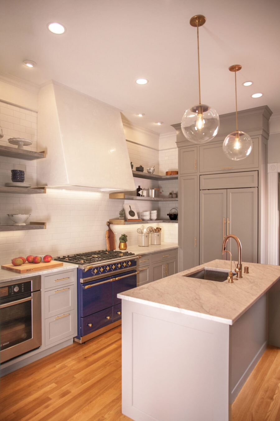 Bright kitchen remodel. Blue range, gray cabinets, marble island, brass fixtures, hardwood floors. Twin Cities.