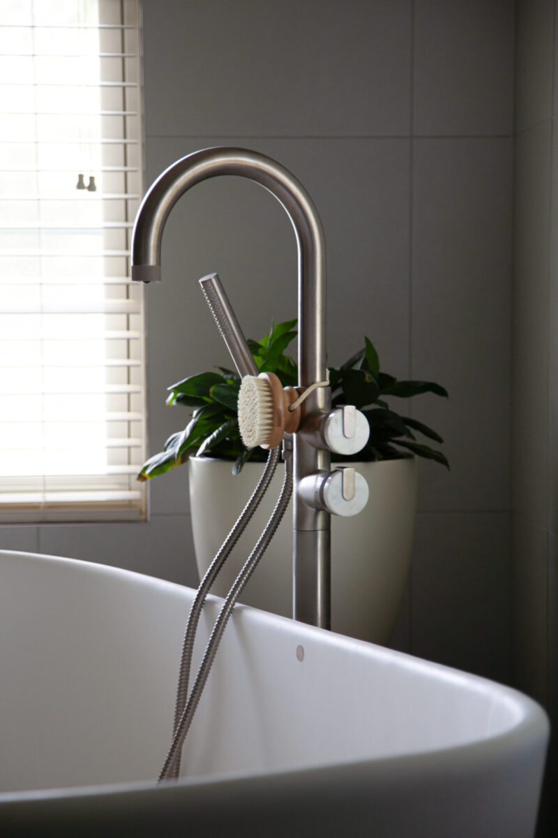 Twin Cities bathroom renovation features white freestanding tub, brushed-metal floor faucet.