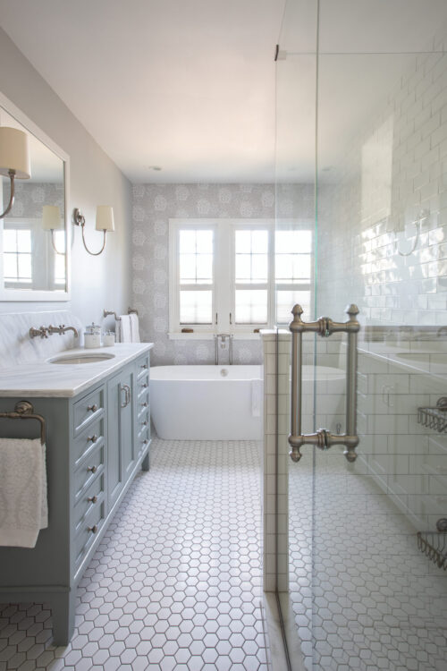 Bright, remodeled bathroom. White hexagon floor, freestanding tub, shower.