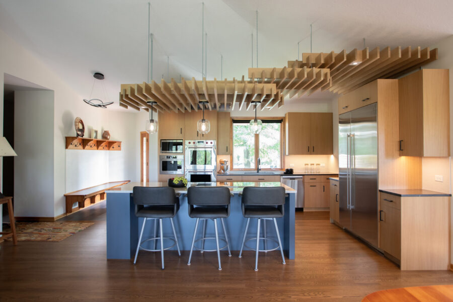 Twin Cities kitchen remodel features light wood cabinetry, a blue island, and a unique wooden slat ceiling.