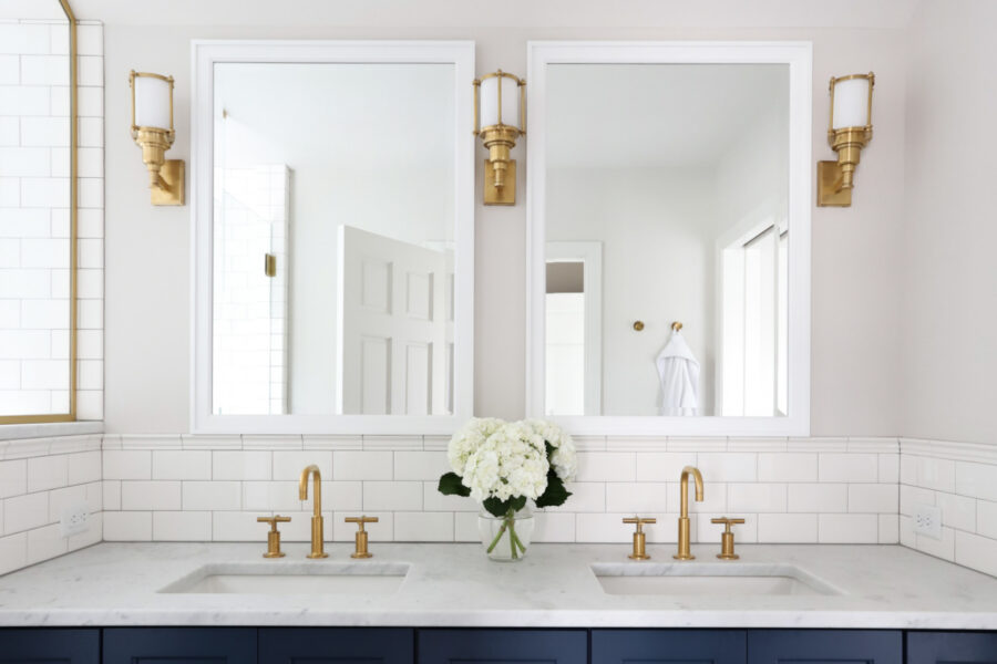 Twin Cities bathroom remodel features dual marble vanity, brass fixtures, subway tile, and dark cabinets.