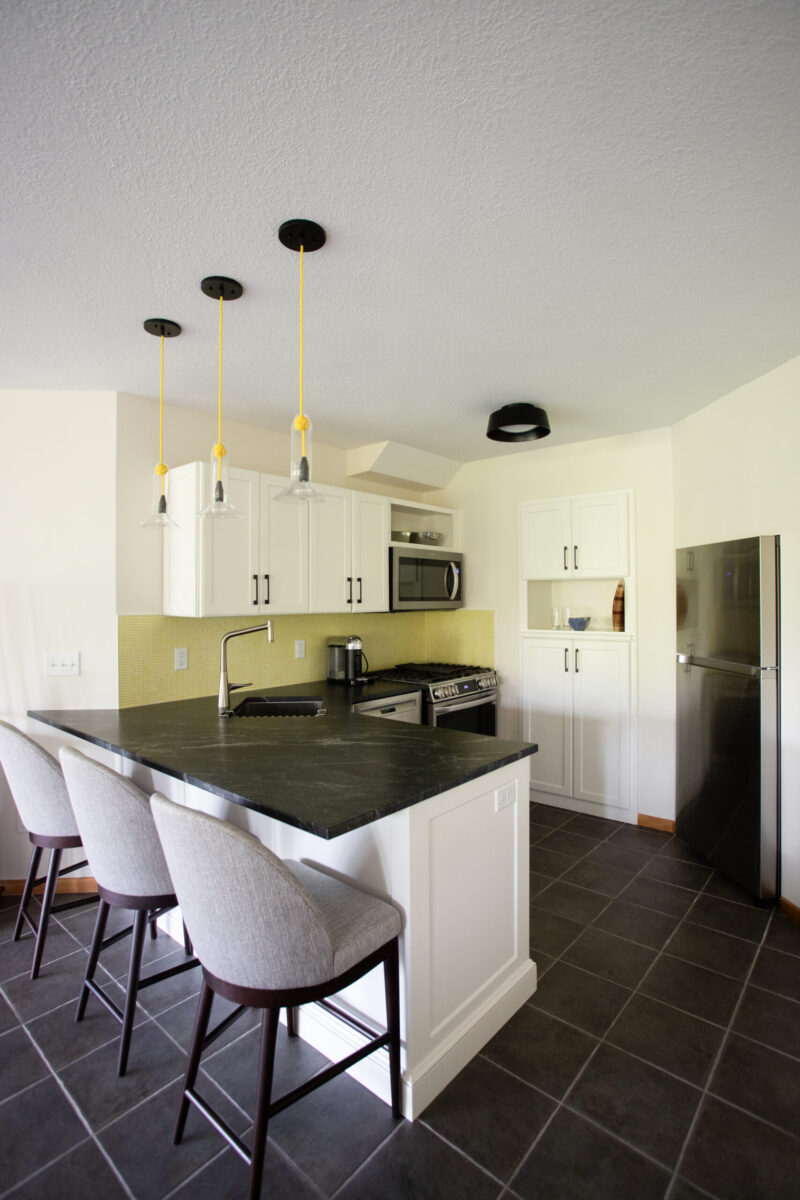 Twin Cities kitchen remodel: white cabinets, dark counters, yellow backsplash, island.