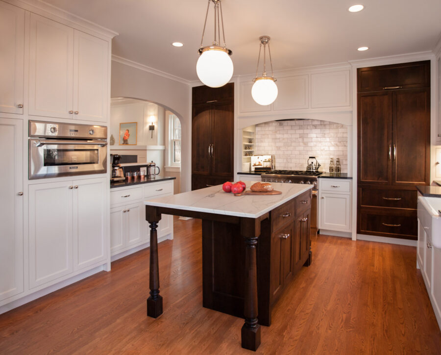 Twin Cities kitchen remodel features white-and-dark cabinetry, marble, hardwood, and bright lighting.