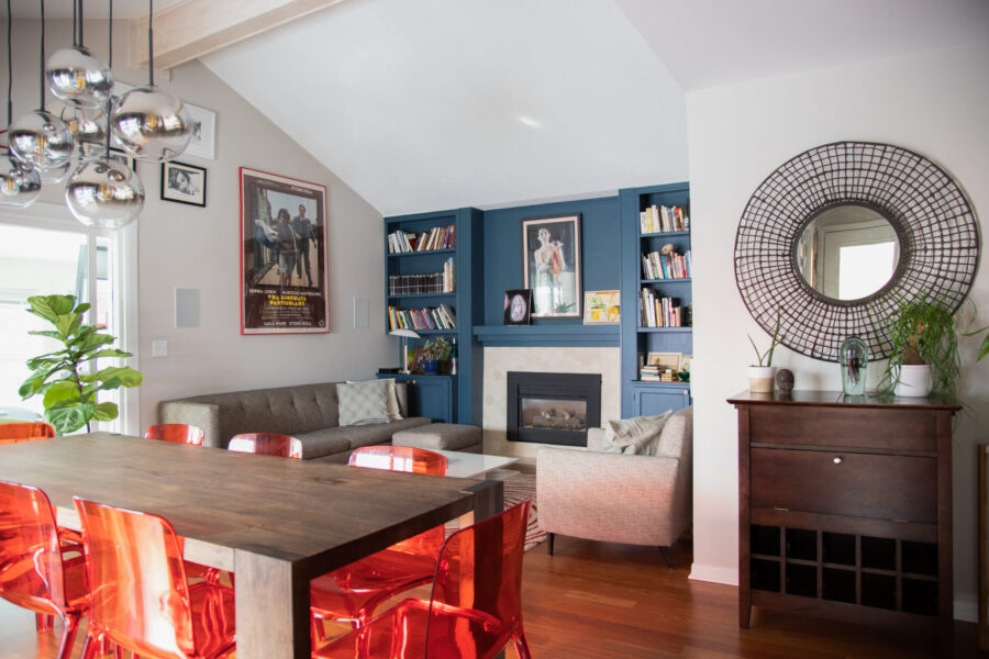 Vaulted Twin Cities design-build boasts blue built-ins, wood flooring, bold orange chairs.