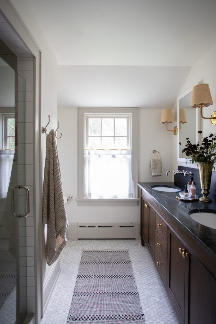 Luxurious bathroom remodel features dark vanity, hexagon tile flooring, brass fixtures, Twin Cities.