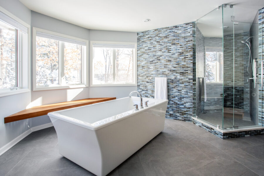 Bathroom renovation delivers freestanding tub, glass shower, mosaic tile wall.