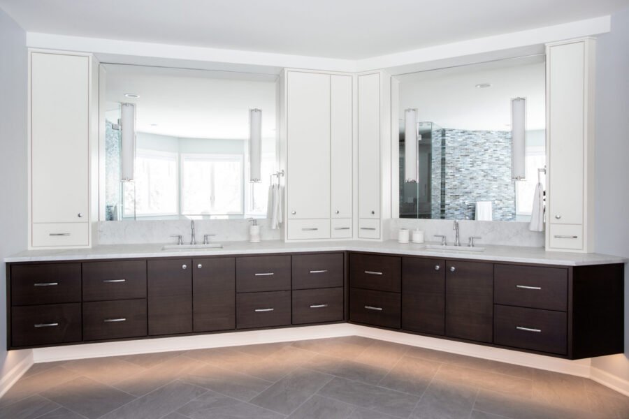 Bathroom design features floating dark vanities, white uppers, marble, and undercabinet lighting.
