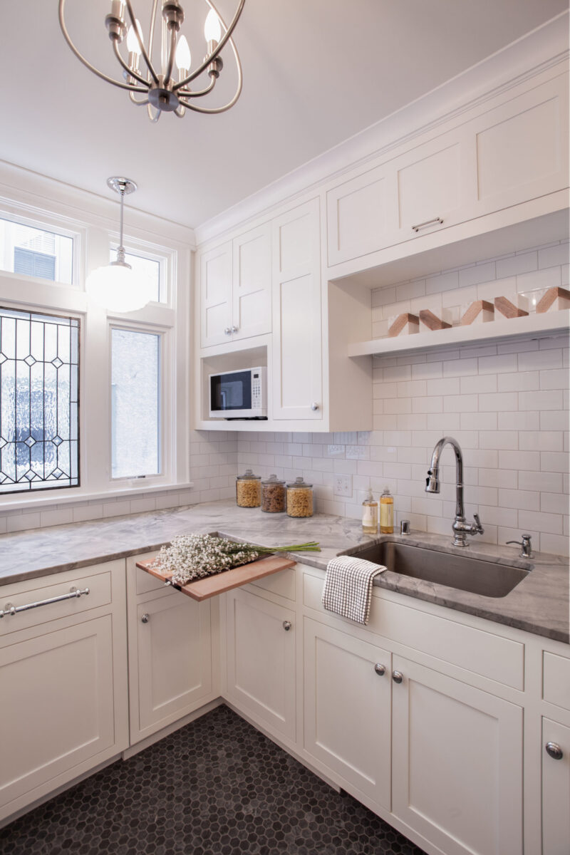 Bright Twin Cities kitchen remodel features white shaker cabinets, gray marble counters, subway tile, dark hex floor.