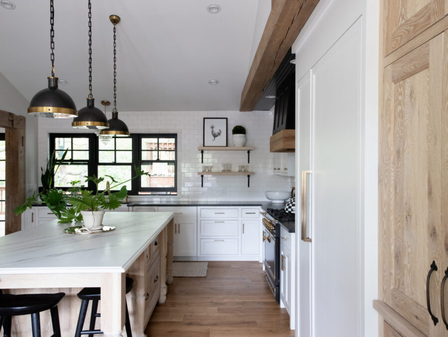 White subway tile, black windows, wood island, and pendant lights furnish this Twin Cities kitchen remodel.
