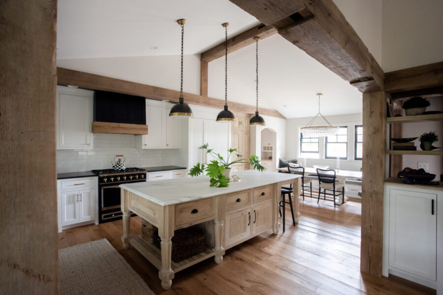 White cabinets, dark counters, exposed wood beams, and a natural wood island accent this Twin Cities kitchen remodel.