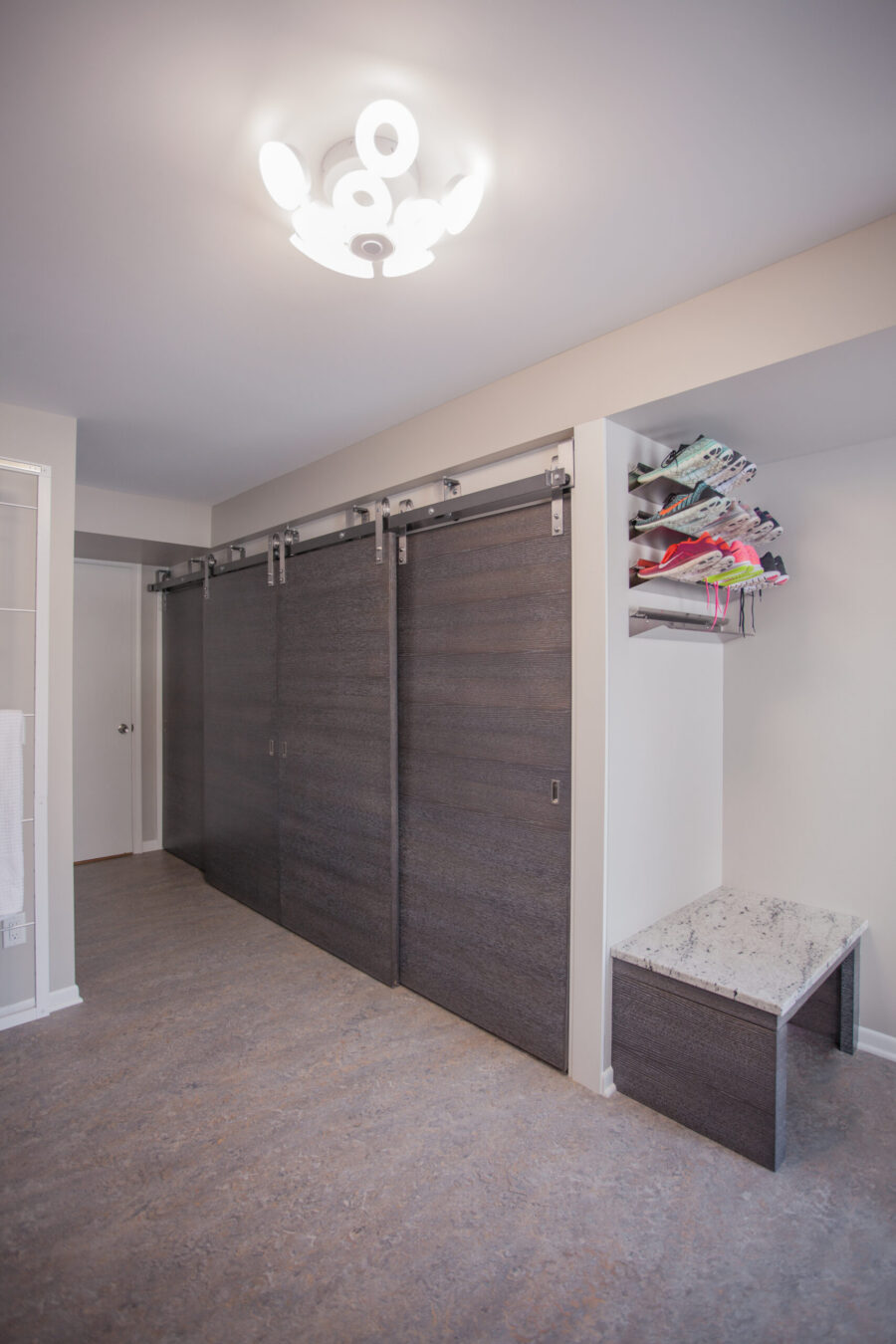 Darkwood-look barn-doors, granite bench, shoe-storage, unique lighting, home-renovation.