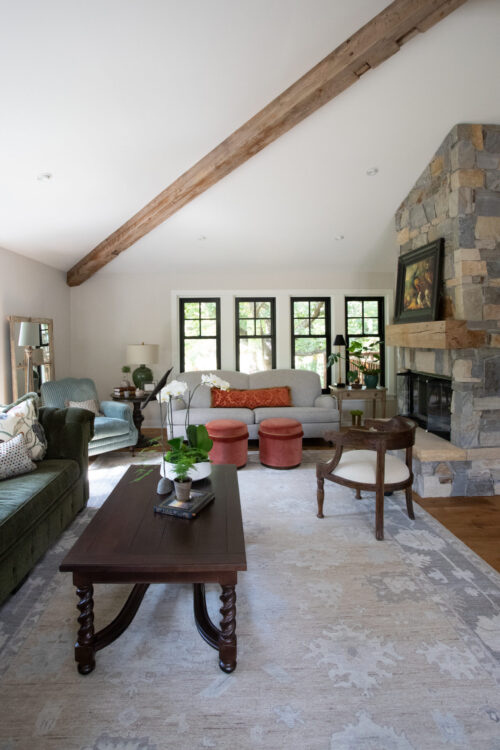 Sunlight fills living-room with reclaimed-timber-beam and coursed-stone fireplace-mantel