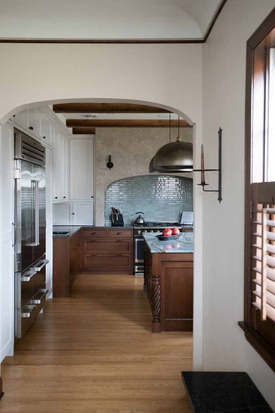 Twin Cities kitchen remodel features dark wood, white cabinetry, blue tile, and stainless steel appliances.