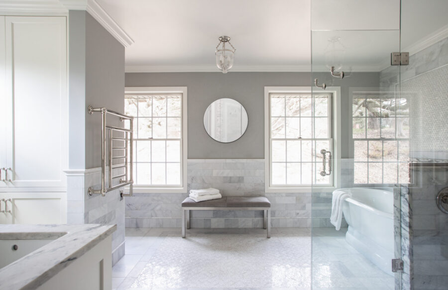 Luxurious bathroom remodel integrates polished marble, plentiful natural light, glass enclosure.
