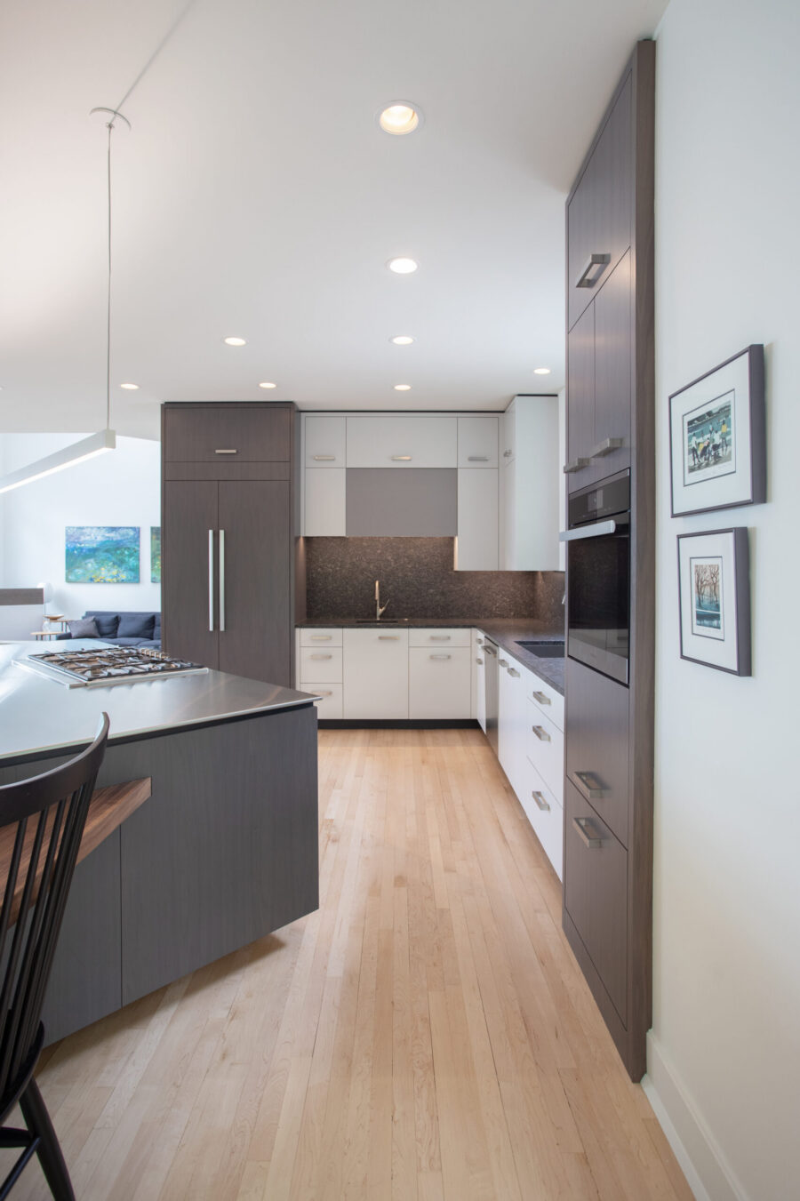 Contemporary Twin Cities kitchen remodel utilizes dark, white cabinetry, light wood floors, recessed illumination.